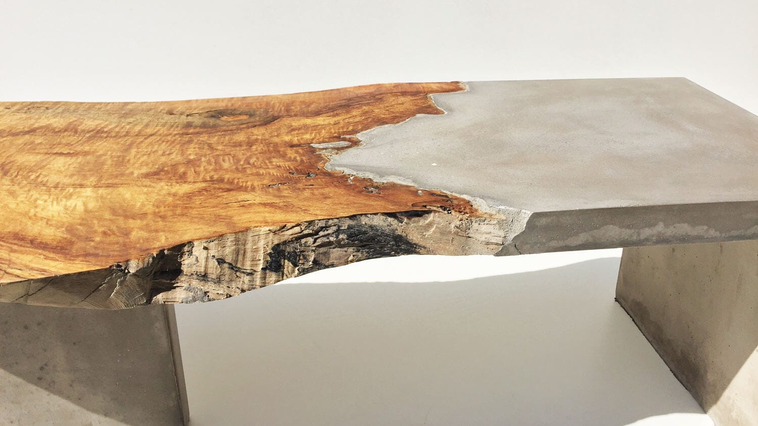 A detailed view of the fusion of driftwood and concrete in a Brad Teasdale bench