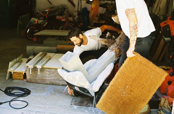 Brad Teasdale lifting up a concrete-and-driftwood bench